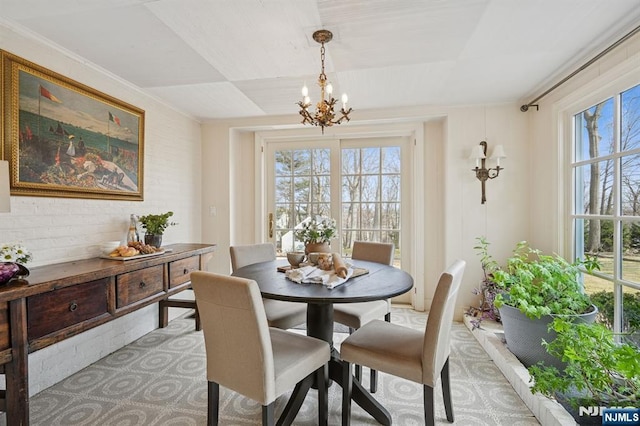 dining area with an inviting chandelier and brick wall