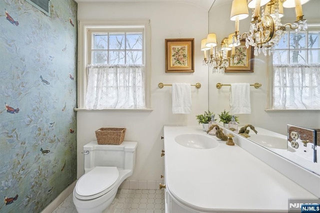 full bathroom featuring vanity, toilet, baseboards, and a chandelier