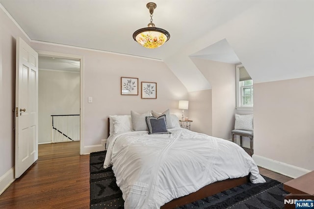 bedroom with vaulted ceiling, baseboards, and wood finished floors