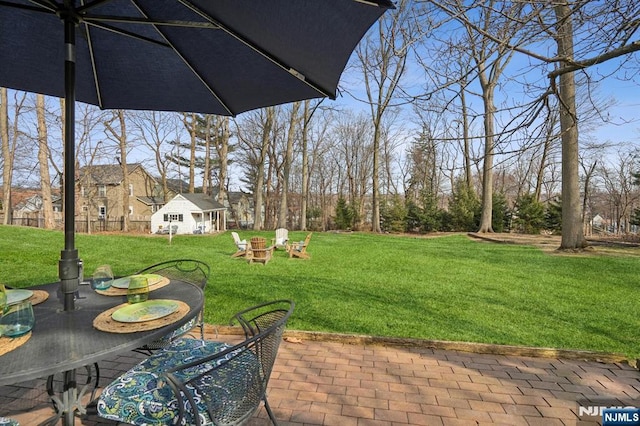 view of yard featuring a patio area, an outdoor structure, and an outdoor fire pit