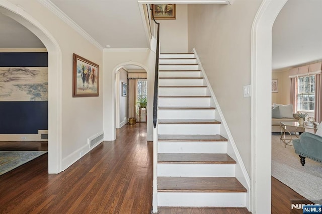 stairs featuring visible vents, arched walkways, and wood finished floors