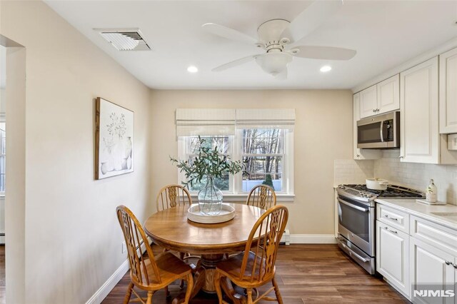 dining room with visible vents, baseboards, a ceiling fan, and dark wood-style flooring