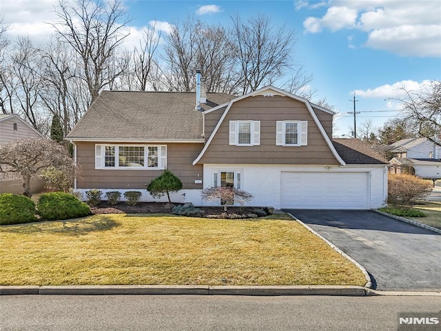 view of front of property featuring roof with shingles, a gambrel roof, a front lawn, aphalt driveway, and brick siding