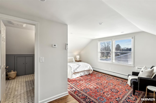 bedroom featuring baseboards, a baseboard heating unit, and lofted ceiling