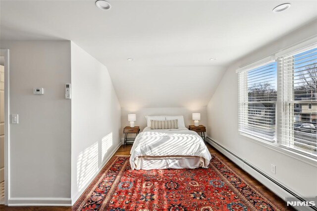 bedroom featuring wood finished floors, baseboards, recessed lighting, vaulted ceiling, and a baseboard heating unit