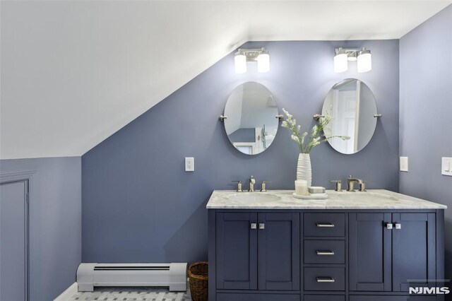 full bathroom featuring a baseboard heating unit, vaulted ceiling, and a sink