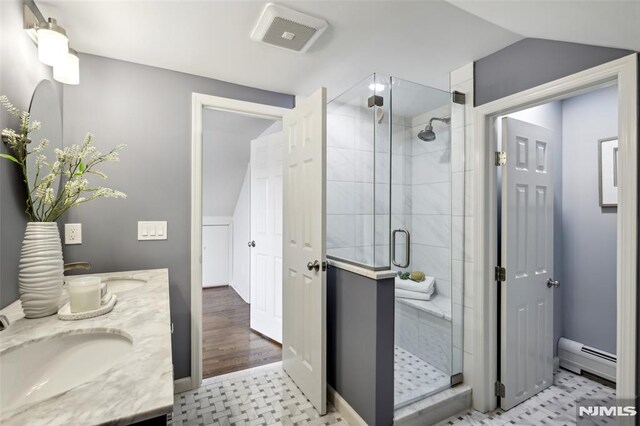 bathroom with visible vents, a baseboard radiator, lofted ceiling, a stall shower, and a sink