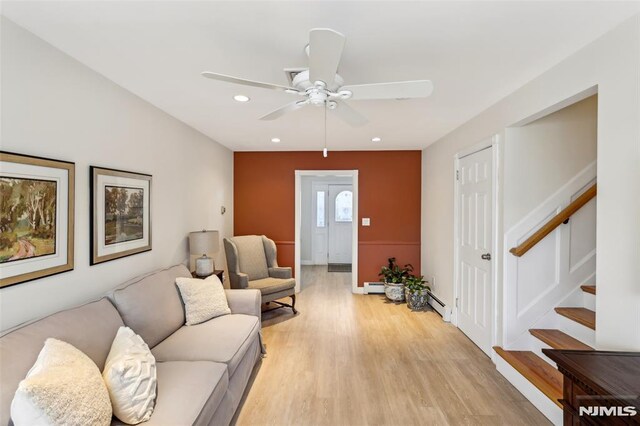 living area featuring stairway, recessed lighting, ceiling fan, light wood-type flooring, and baseboard heating