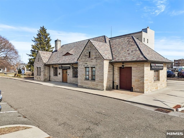 french country home featuring a high end roof and a chimney