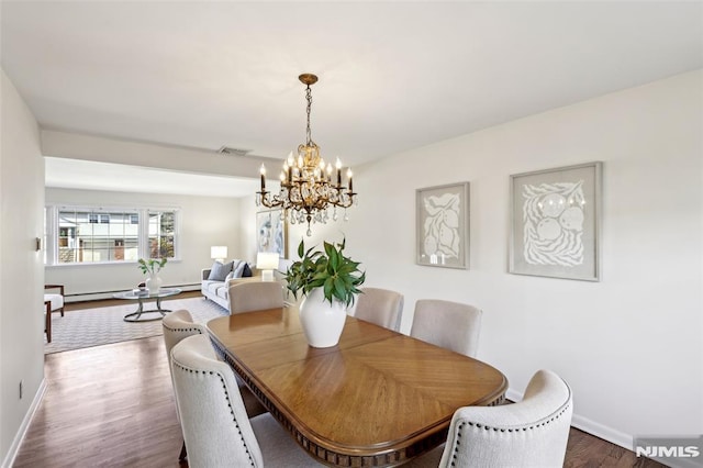 dining room featuring an inviting chandelier, wood finished floors, visible vents, and baseboards