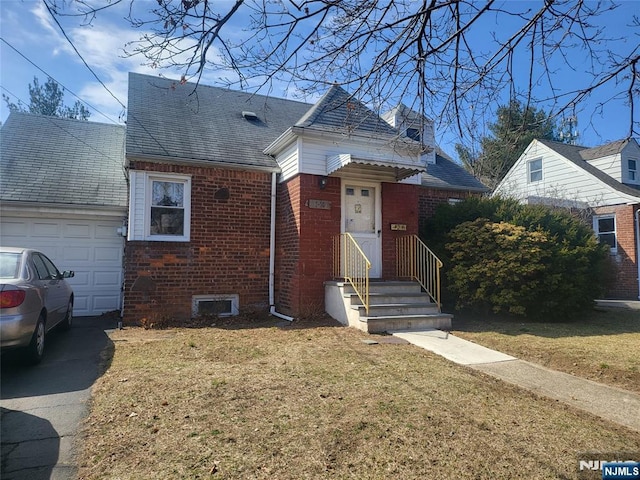 view of front of property featuring brick siding, driveway, an attached garage, and a front lawn