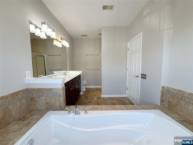 full bath with visible vents, a bath, and vanity