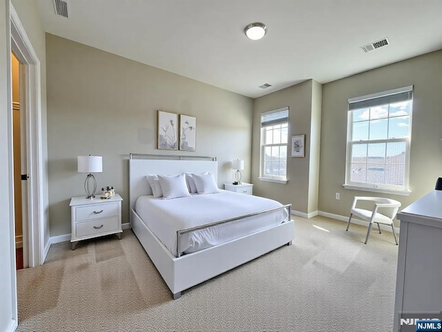 bedroom featuring visible vents, baseboards, and light colored carpet