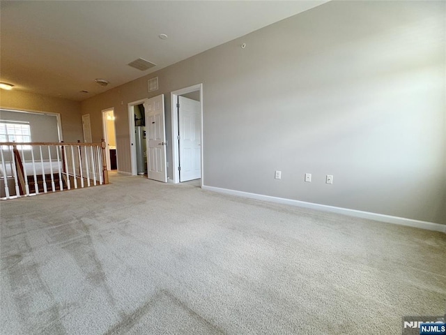 carpeted spare room featuring baseboards