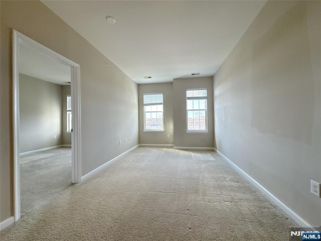 spare room with baseboards and carpet floors