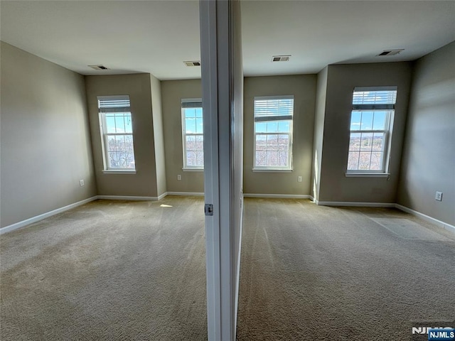 spare room with visible vents, baseboards, and carpet