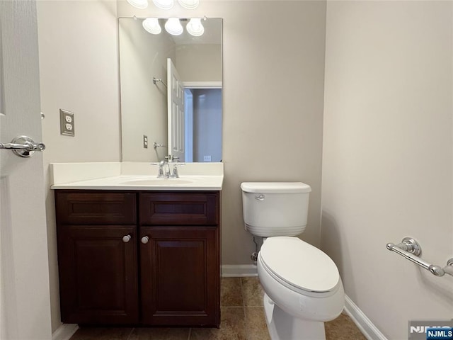 bathroom with tile patterned floors, baseboards, toilet, and vanity