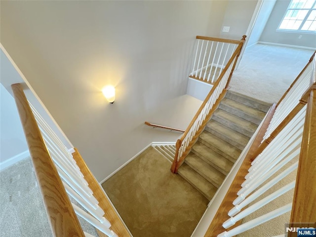 stairway with baseboards and carpet floors