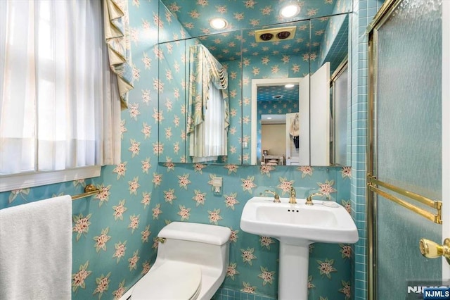 bathroom featuring wallpapered walls, toilet, and a sink