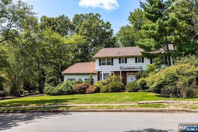 view of front of property featuring brick siding and a front lawn