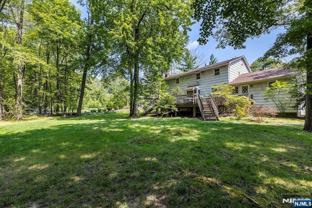 view of yard with a deck and stairs