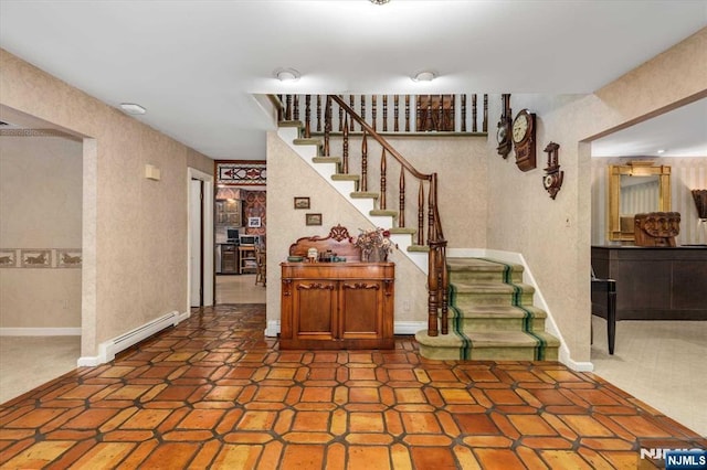 staircase with baseboard heating, baseboards, and a textured wall