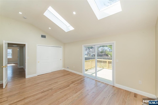 spare room featuring a skylight, a healthy amount of sunlight, visible vents, and light wood finished floors