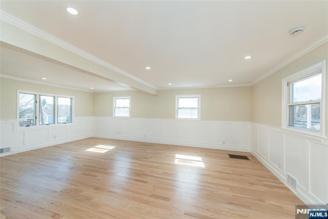 spare room with visible vents, a wainscoted wall, and light wood finished floors