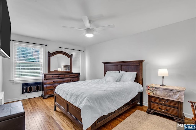 bedroom featuring light wood finished floors, ceiling fan, and baseboards