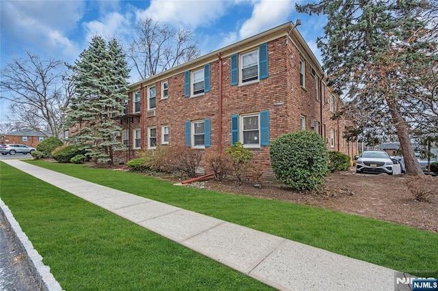 view of front facade featuring brick siding and a front yard