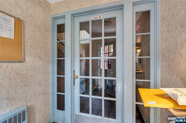 view of exterior entry with visible vents and stucco siding