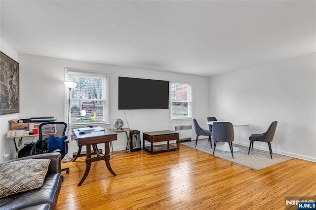 interior space with radiator, baseboards, and light wood-type flooring