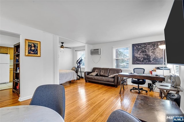 living area with light wood-type flooring and a wall unit AC