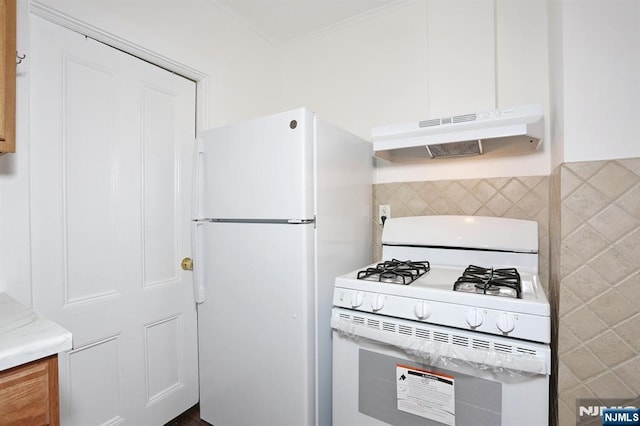 kitchen with white appliances, light countertops, tasteful backsplash, and under cabinet range hood