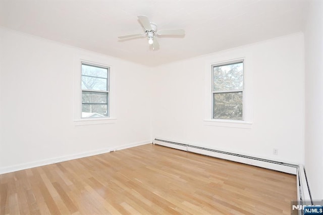 unfurnished room featuring a ceiling fan, baseboards, ornamental molding, a baseboard heating unit, and light wood-type flooring