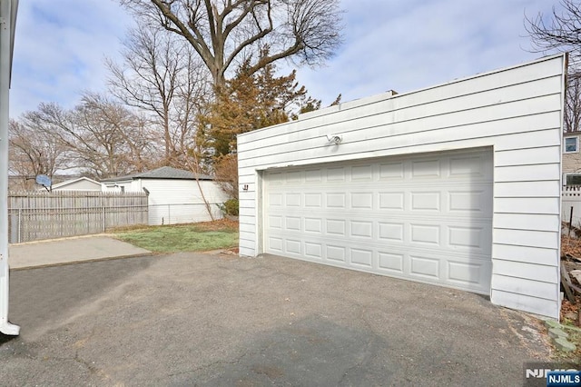 detached garage featuring fence