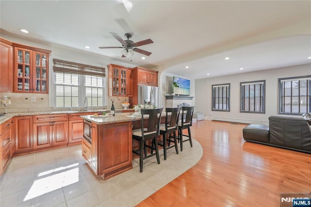 kitchen featuring a kitchen bar, plenty of natural light, open floor plan, and appliances with stainless steel finishes