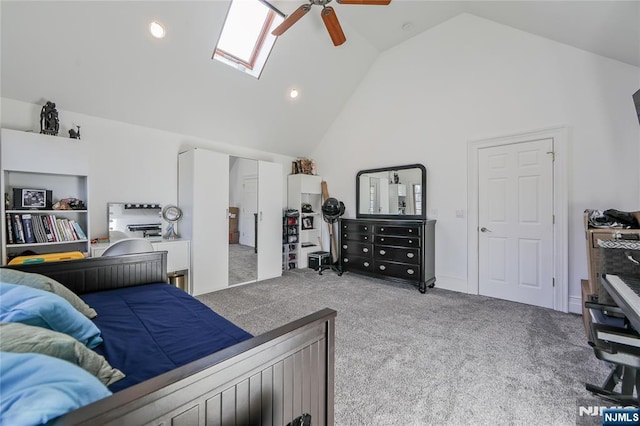 carpeted bedroom featuring high vaulted ceiling, a skylight, and a ceiling fan