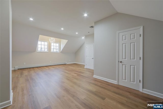 bonus room with visible vents, wood finished floors, baseboards, lofted ceiling, and baseboard heating