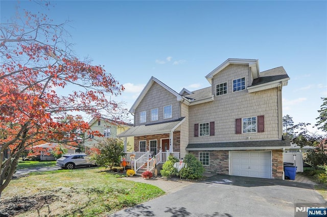 view of front of property featuring driveway, stone siding, a porch, an attached garage, and a shingled roof