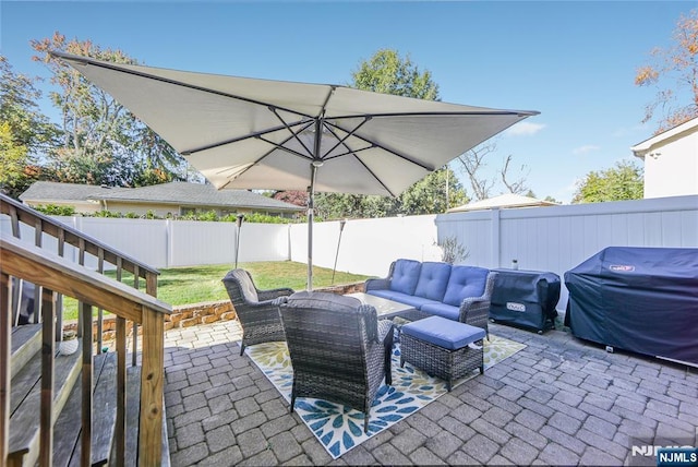 view of patio with an outdoor living space, a fenced backyard, and grilling area