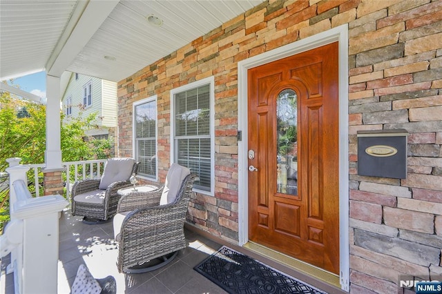 entrance to property with brick siding and a porch