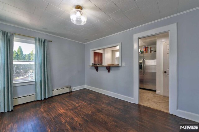 unfurnished room featuring baseboards, crown molding, and hardwood / wood-style flooring