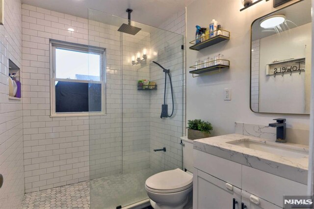 bathroom with a walk in shower, toilet, and vanity