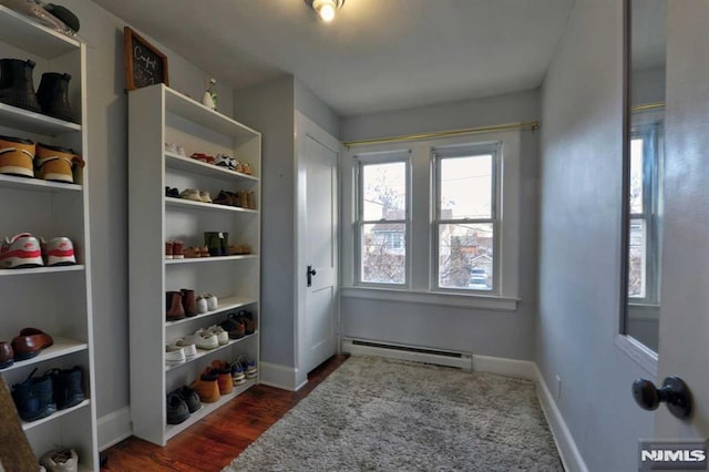 mudroom featuring dark wood-style flooring, built in features, baseboards, and a baseboard radiator