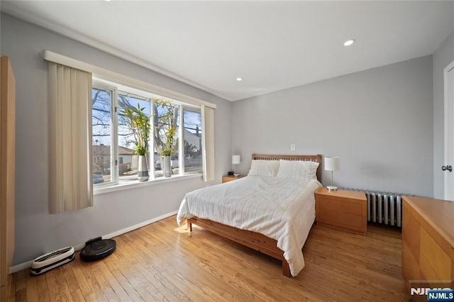 bedroom featuring recessed lighting, baseboards, radiator, and wood finished floors