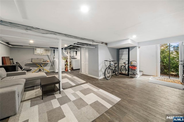 below grade area featuring wood finished floors, baseboards, and washing machine and clothes dryer