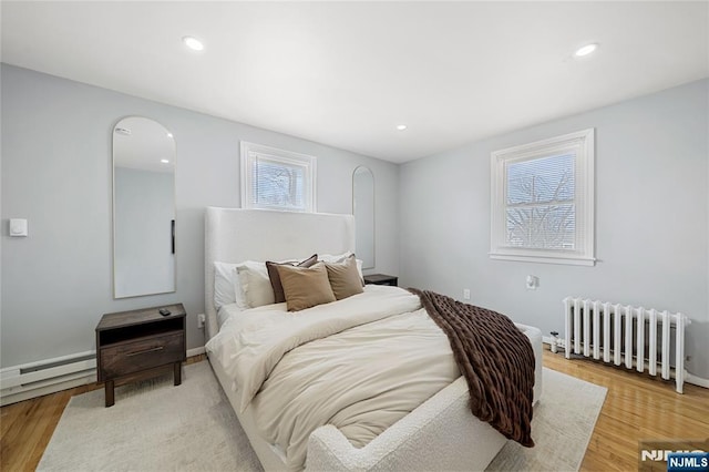 bedroom featuring recessed lighting, radiator, arched walkways, and light wood-type flooring