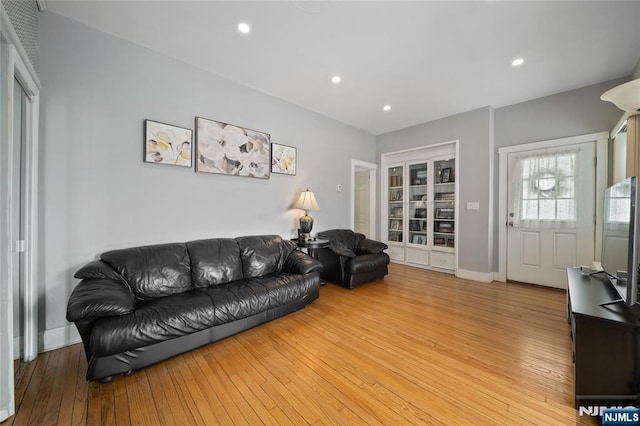 living area featuring recessed lighting, light wood-type flooring, and baseboards