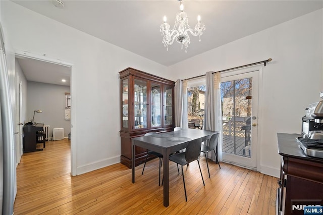 dining room featuring a chandelier, light wood-style flooring, and baseboards